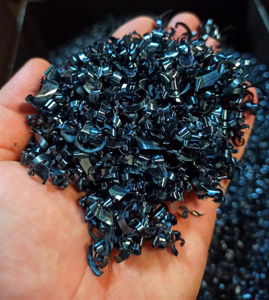 Metallspäne in Hand – CNC Teile Serienfertigung